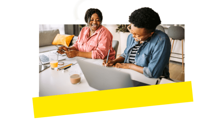 Zwei Kollegen nutzen VoIP-Tools und arbeiten lachend zusammen.